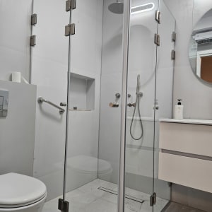 מקלחון זכוכית עם ראש מקלחת עגול וברזים