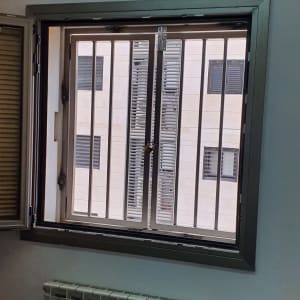 חלון עם סורגים מתכתיים ומסגרת מתכת