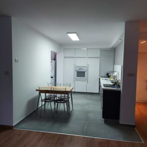 מטבח משופץ עם ארונות לבנים ותאורה חדשה