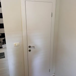 דלת לבנה עם ידית מתכת בחדר פנימי