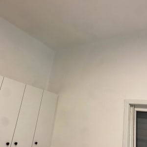 ארונות מטבח לבנים עם ידיות שחורות על קיר לבן