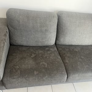 ספה אפורה עם כתמים על המושב