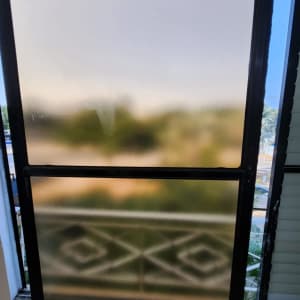 חלון זכוכית עם נוף מטושטש ברקע