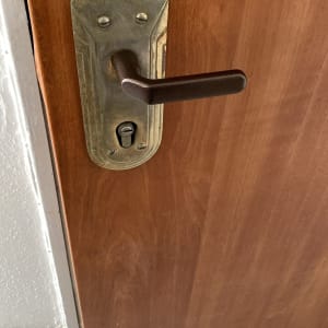 ידית דלת מתכת עם מנעול על דלת עץ