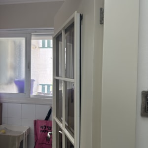 דלת לבנה עם חלונות זכוכית בחדר פנימי