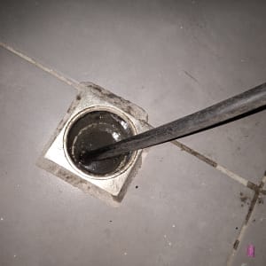 ניקוז מים עם כלי עבודה על רצפה אפורה