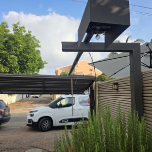 שער חשמלי עם מכוניות חונות לידו