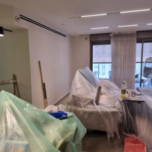 חדר עם רהיטים מכוסים בניילון לקראת צביעה