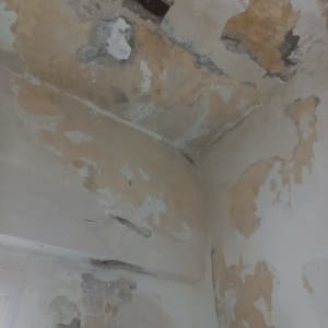 קיר מתקלף עם טיח מתפורר וצבע מתקלף