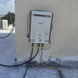 מחמם מים מותקן על קיר חיצוני עם חיבורים וצינורות