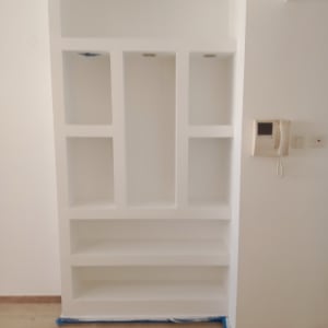 מדף לבן מובנה בקיר עם טלפון קווי