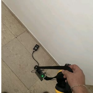 אדם מחזיק מכשיר לגילוי נזילות עם אוזניות