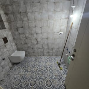 חדר אמבטיה עם אריחים חדשים ומטאטא