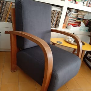 כורסה מרופדת בבד אפור עם מסגרת עץ