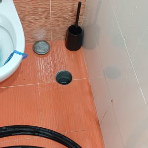 שירותים עם צינור וכלי ניקוי על רצפה רטובה