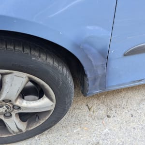 פגוש רכב כחול עם שריטות ונזק קל