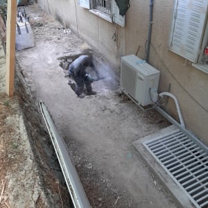 עובד חופר בור עם כלי עבודה חשמלי