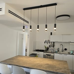 חמישה גופי תאורה תלויים מהתקרה במטבח מודרני