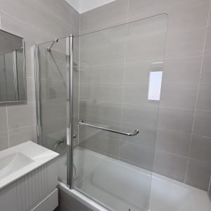 מקלחת עם אמבטיה ודלת זכוכית שקופה