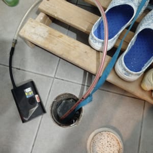 צינור וכלי עבודה ליד פתח ניקוז על רצפה