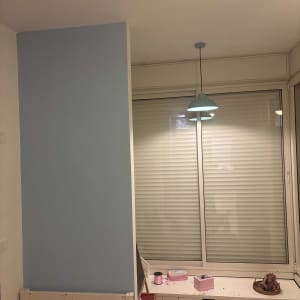 קיר צבוע בכחול עם מנורה תלויה בחדר