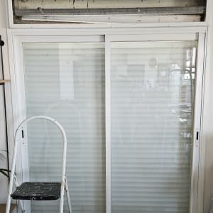 תריסים סגורים עם מסגרת לבנה וסולם לידם