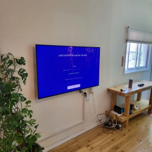 טלוויזיה תלויה על הקיר עם כבלים חשמליים