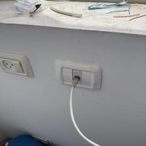 כבל רשת מחובר לשקע בקיר עם חוטים נוספים