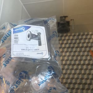 חלקי אינסטלציה באריזת פלסטיק על רקע רצפה