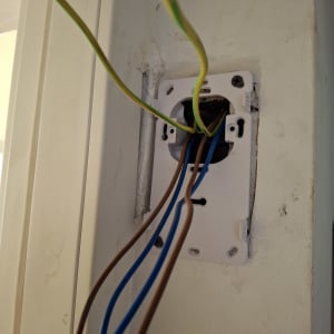 חוטי חשמל יוצאים מקופסת חיבורים בקיר
