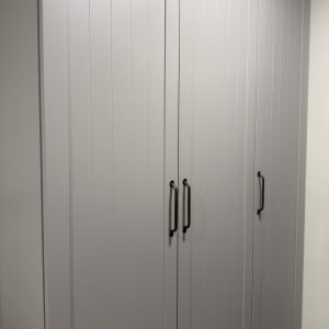 ארון עץ עם ידיות מתכת בעבודת נגרות