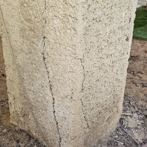 עמוד בטון עם סדקים על הקרקע