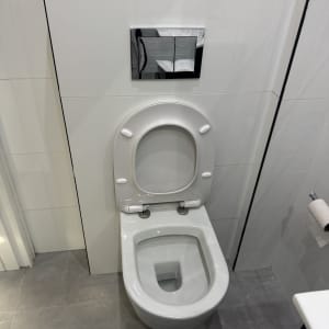 אסלה מותקנת בחדר אמבטיה עם אריחים לבנים