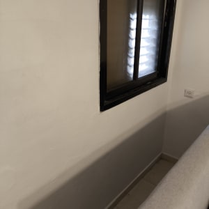 חלון עם מסגרת שחורה על קיר לבן