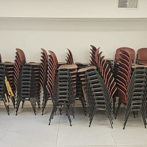 ערימת כיסאות מוערמים בחדר ריק