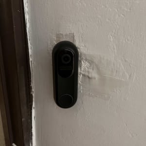 פעמון דלת חכם מותקן על קיר לבן