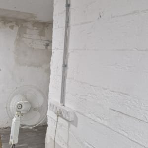 שקעי חשמל על קיר עם מאוורר עומד