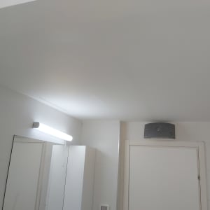 תקרה חלקה עם גוף תאורה ומזגן על הקיר