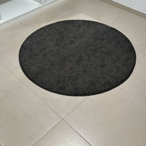 שטיח עגול כהה על רצפה בהירה