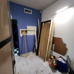 חדר עם דלתות, מסגרת עץ ושקיות על הרצפה