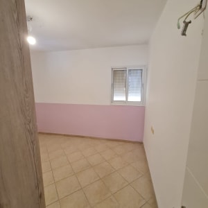 חדר צבוע עם קיר ורוד ורצפת אריחים