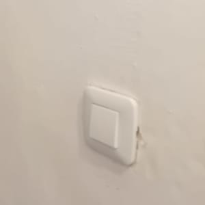 מתג חשמל לבן מותקן על קיר