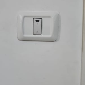 מתג חשמלי לבן על קיר לבן