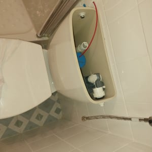 מיכל הדחה פתוח עם צינור מים בחדר אמבטיה