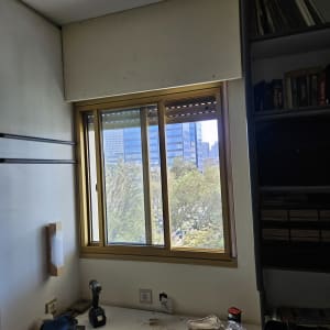 חלון עם תריסים וכלי עבודה על שולחן