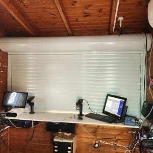 תריס אלומיניום סגור עם שולחן עבודה ומחשבים