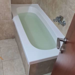 אמבטיה מלאה מים עם חיפוי קיר קרמי