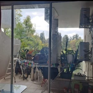 חלון זכוכית גדול עם וילון אדום בצד