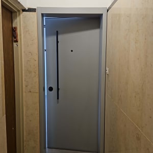 דלת אפורה במסדרון עם קירות בהירים