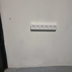 שקע חשמל עם שישה חיבורים על קיר לבן